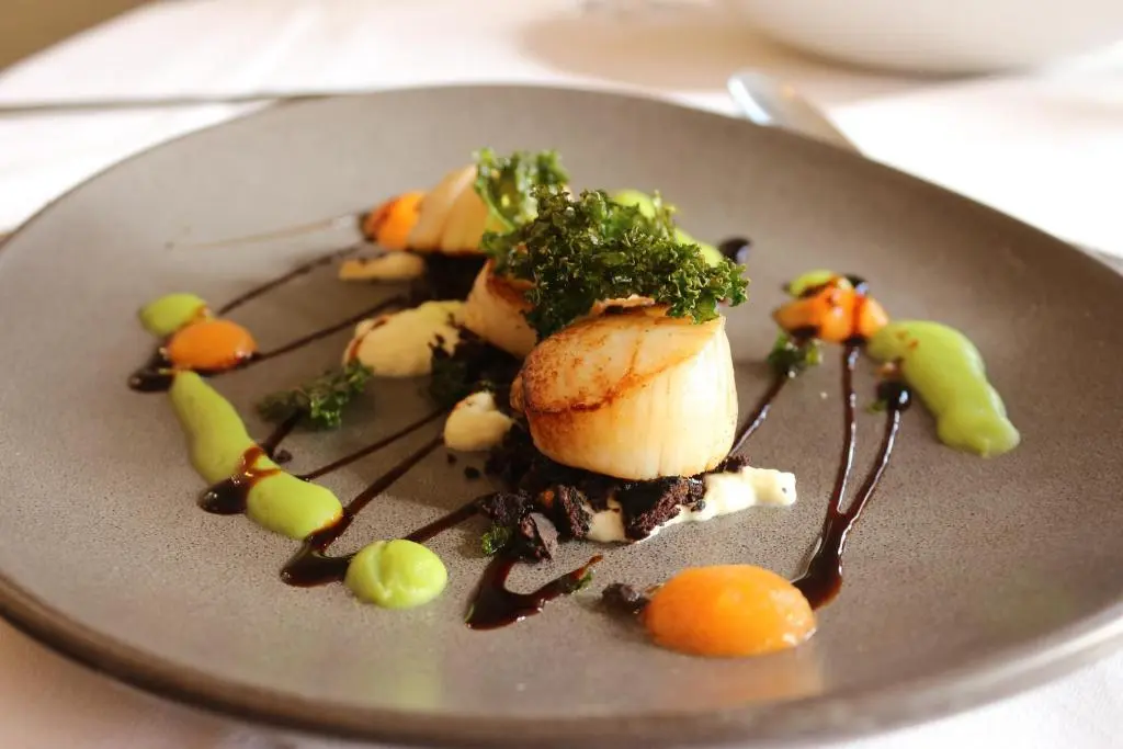 a plate of food with vegetables and sauce on it at Craiglynne Hotel in Grantown on Spey