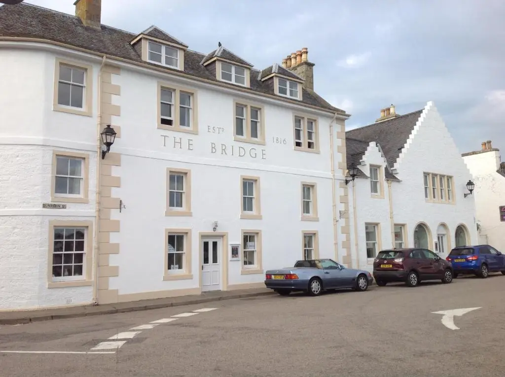 a white building with the bridge written on it at The Bridge Helmsdale in Helmsdale