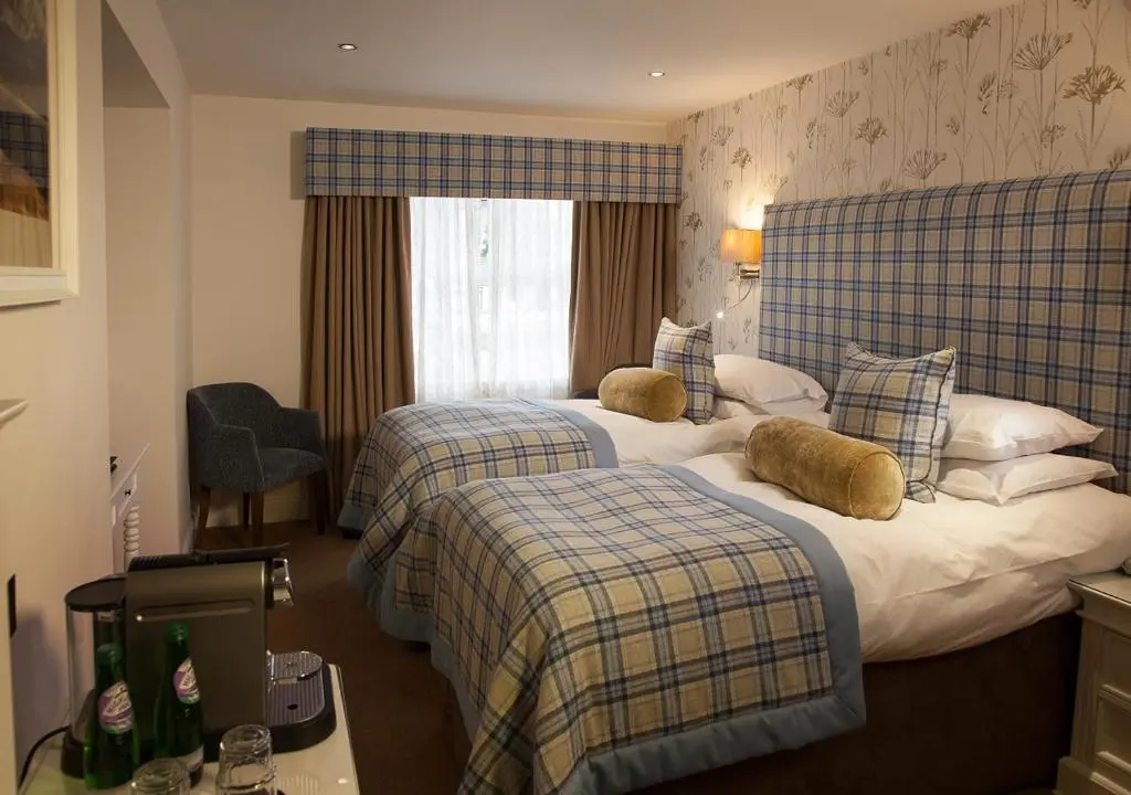 a hotel room with two beds and a window at The Lovat, Loch Ness in Fort Augustus