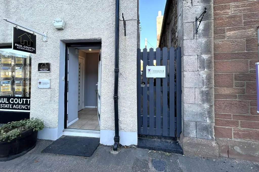 a door to a building with a sign on it at Thistle Apartment Golspie in Golspie