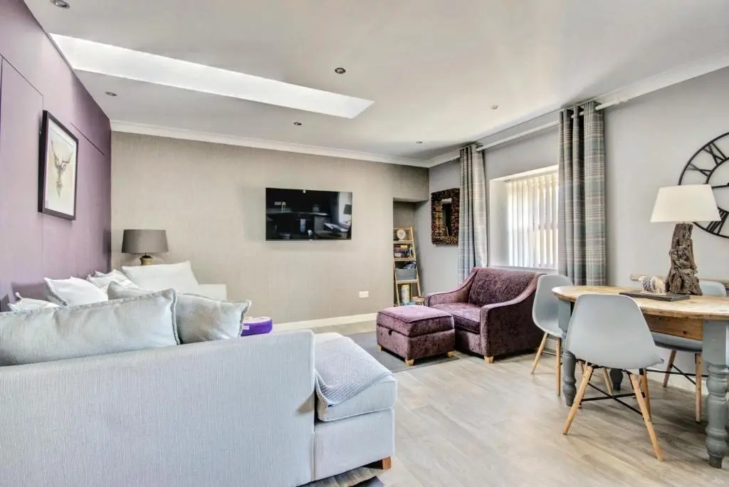 a living room with a couch and a table at Thistle Apartment Golspie in Golspie
