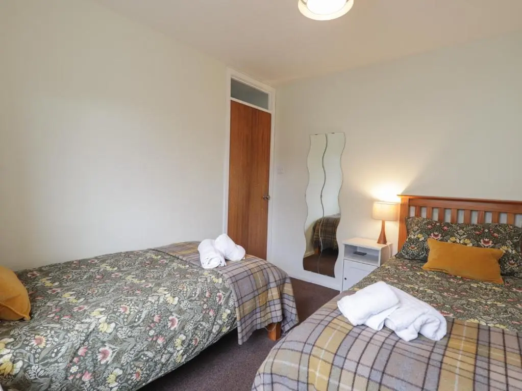 a hotel room with two beds with towels on them at Steam Cottage in Aviemore