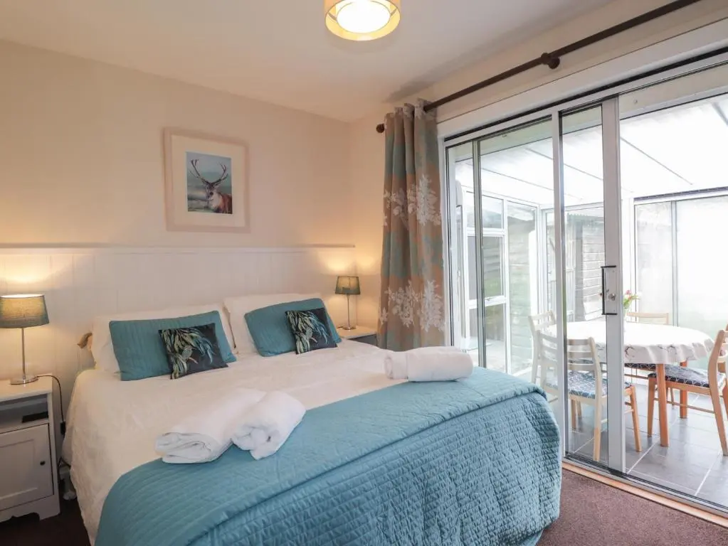 a bedroom with a bed with towels on it at Steam Cottage in Aviemore
