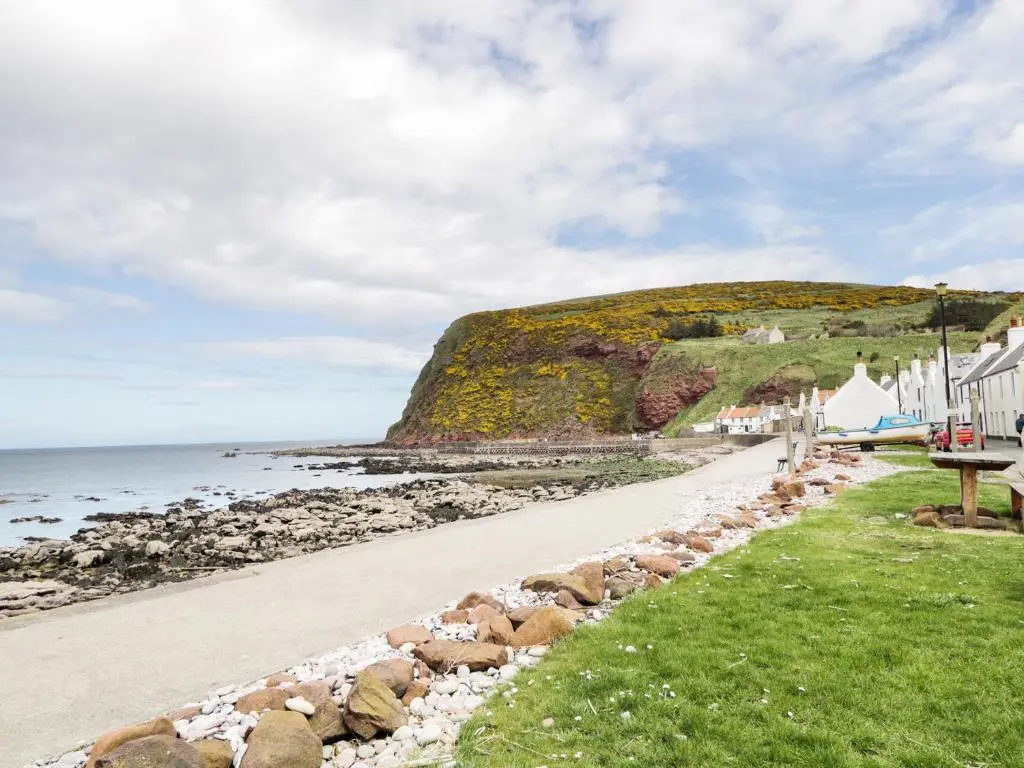 a beach with rocks and houses and the ocean at St Magnus Haven in Pennan