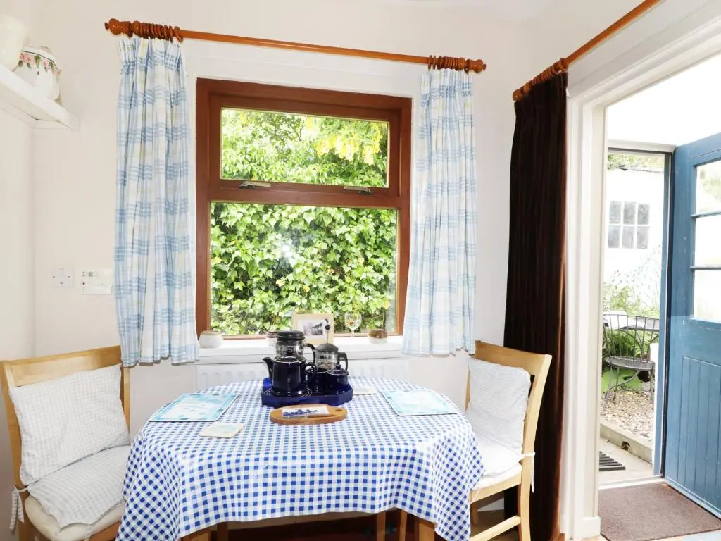 a table with a tea pot on it in a room with a window at St Magnus Haven in Pennan