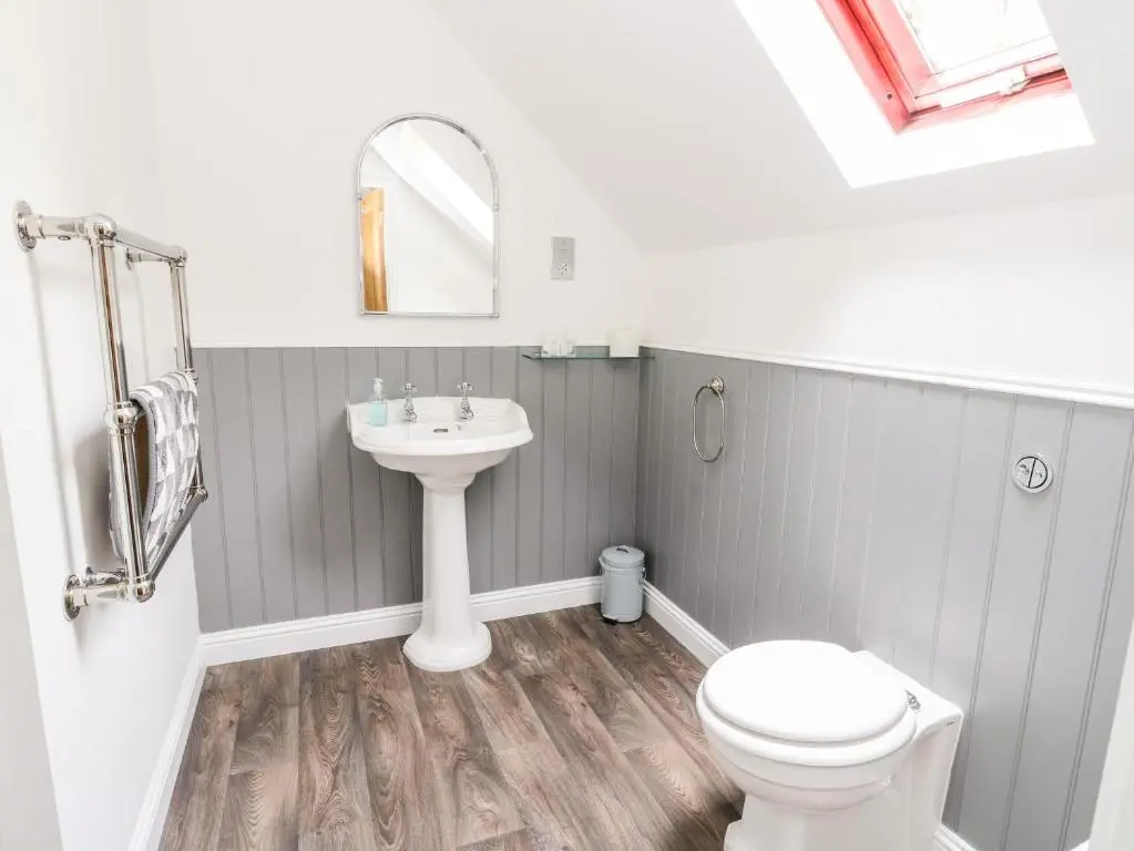 a bathroom with a sink and a toilet and a mirror at Tigh Na Drochit in Garve