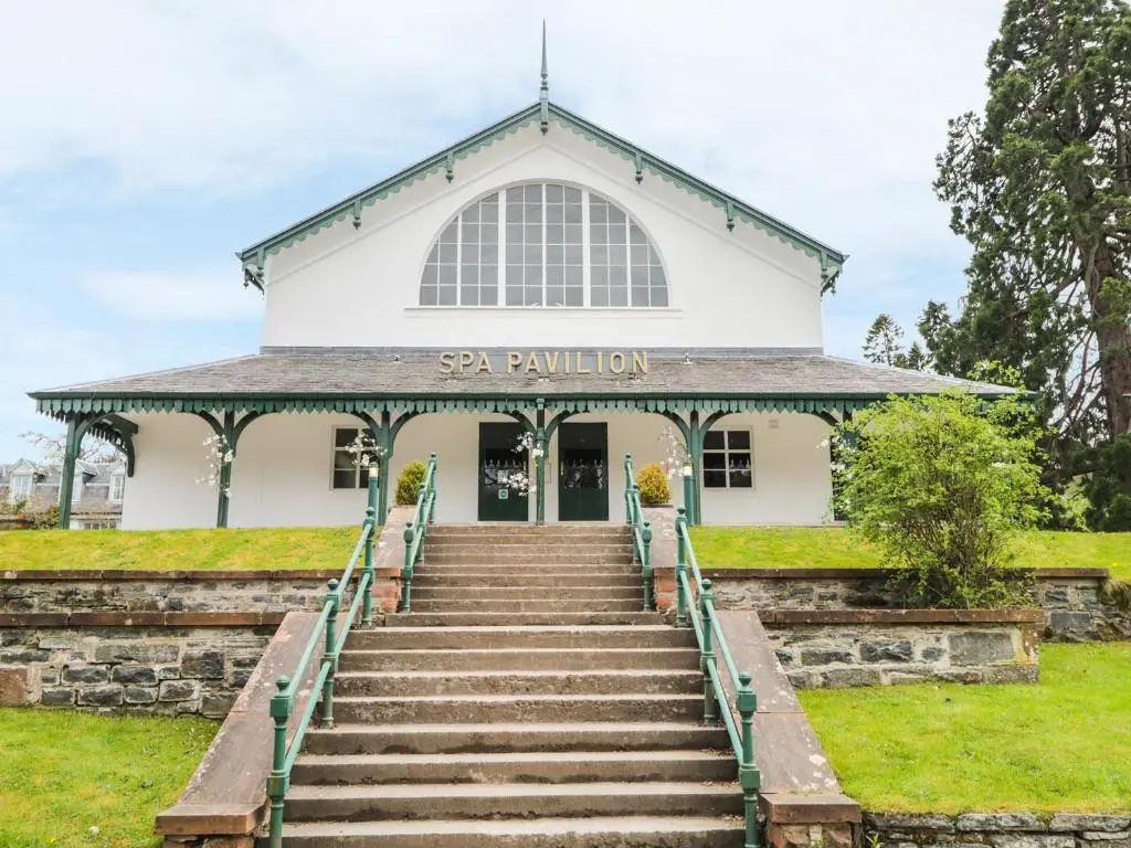 a white building with stairs in front of it at Otter Lodge in Strathpeffer