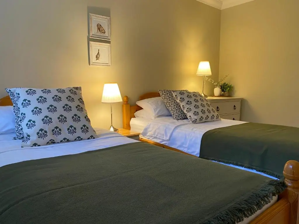 a bedroom with two beds and two lamps at Westwood Cottage in Aboyne
