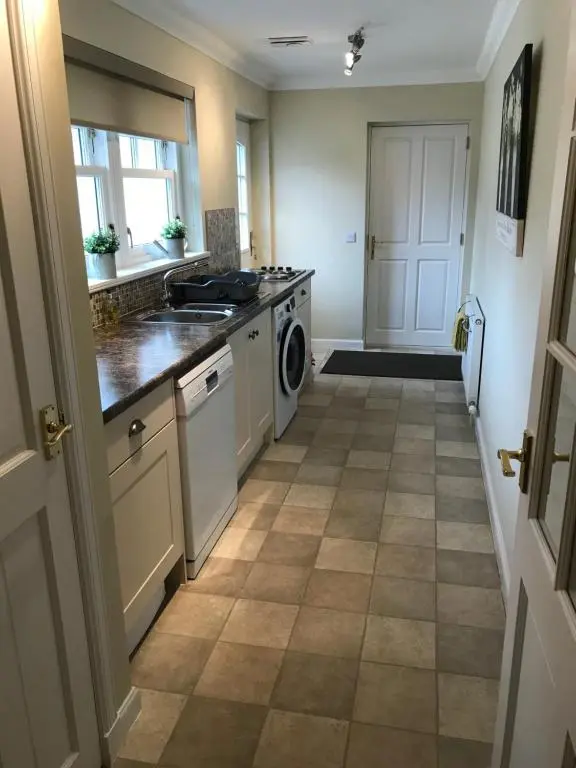 a kitchen with a stove and a dishwasher at Westwood Cottage in Aboyne