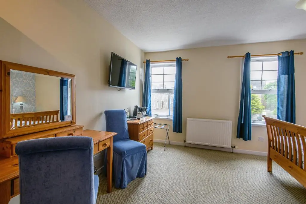 a home office with a desk and a blue chair at The Portland Hotel in Lybster