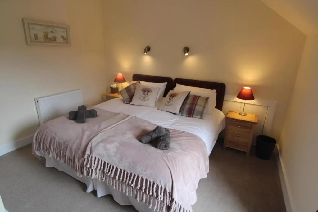 a bedroom with a bed with two teddy bears on it at Easdale House Apartments in Inverness