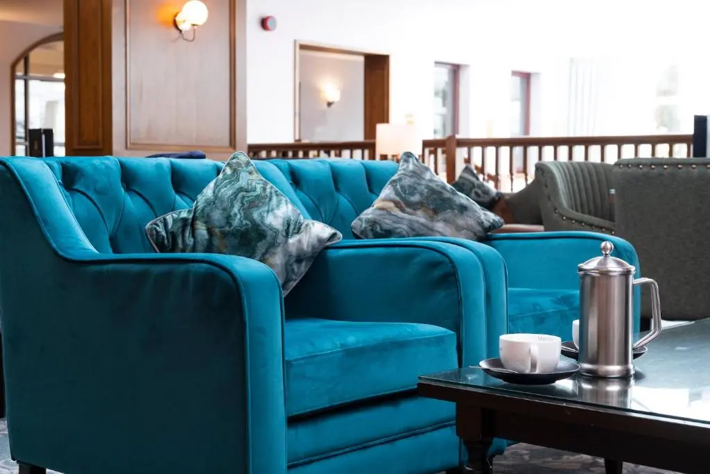 a blue couch in a living room with a table at Kingsmills Hotel in Inverness