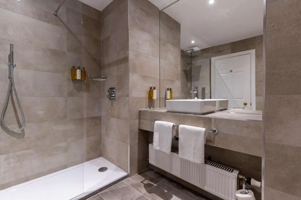 a bathroom with a shower and a sink and a tub at Kingsmills Hotel in Inverness