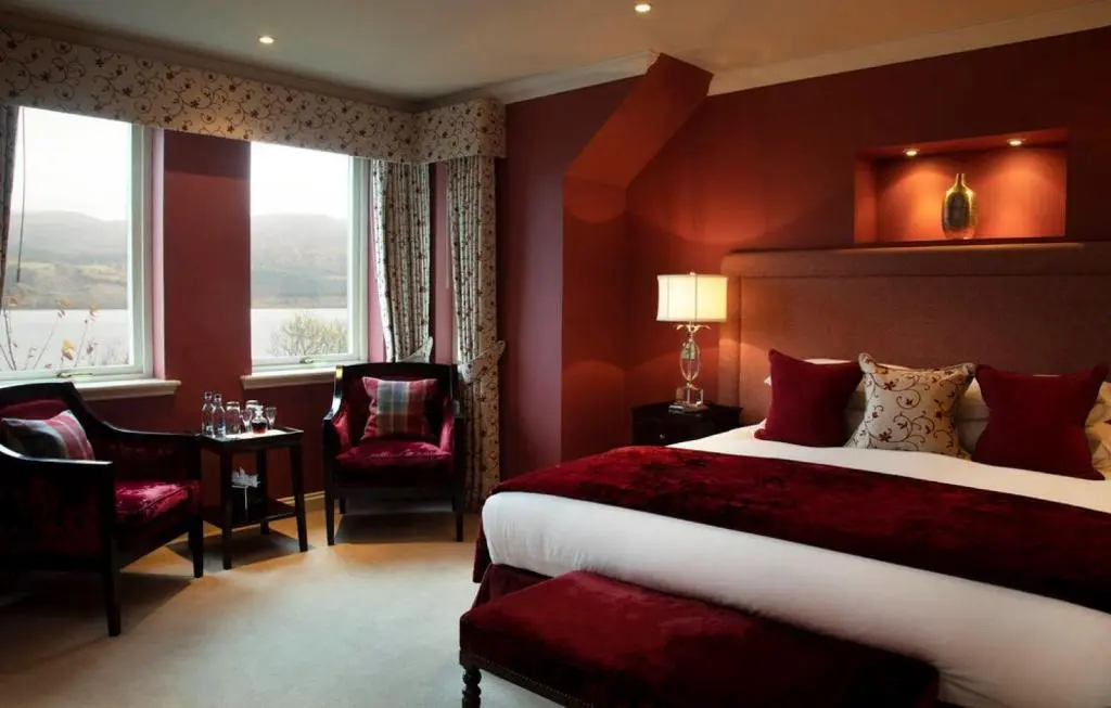 a hotel room with a bed and a table and chairs at Loch Ness Lodge in Drumnadrochit