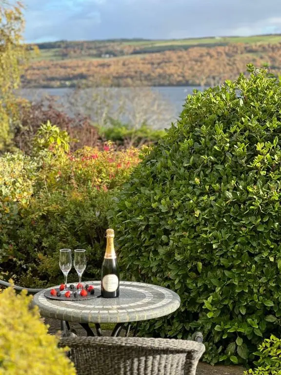 a bottle of champagne and two wine glasses on a table at Loch Ness Lodge in Drumnadrochit