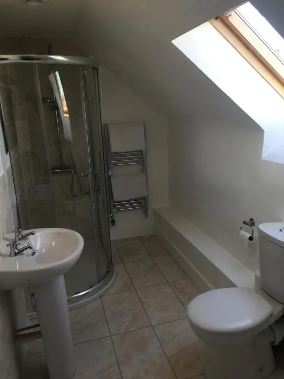 a bathroom with a shower and a toilet and a sink at Whisky Cottage in Inverness