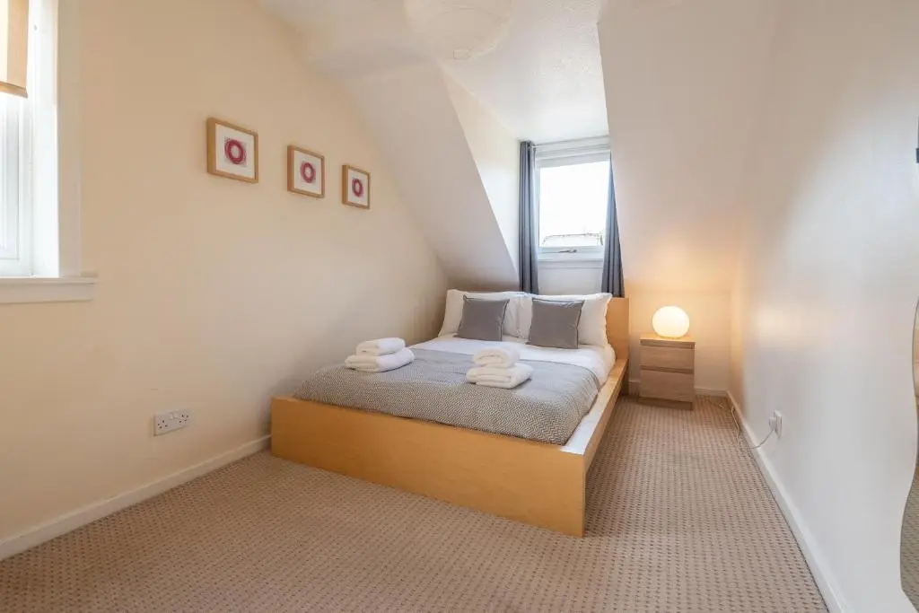 a small bedroom with a bed with towels on it at White Corries in Aviemore