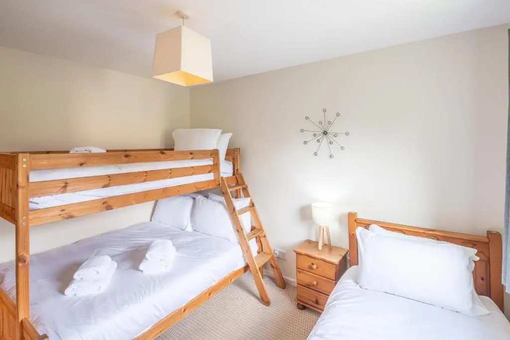 a bedroom with two bunk beds and a clock on the wall at White Corries in Aviemore