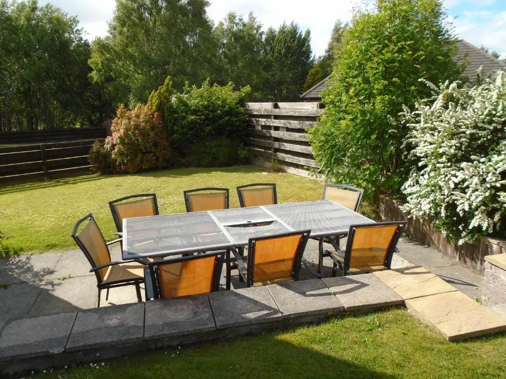 a dining table and chairs in a yard at White Corries in Aviemore
