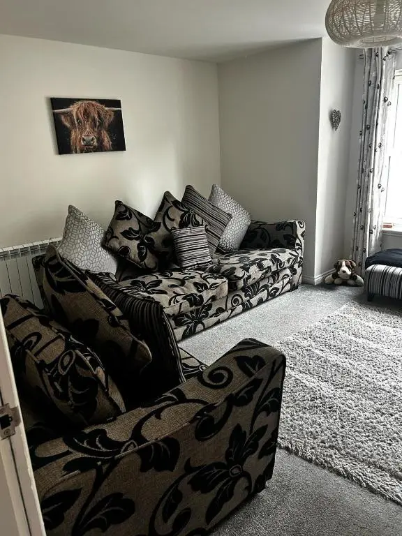 a living room with a couch with pillows at No.3 On The Square in Beauly