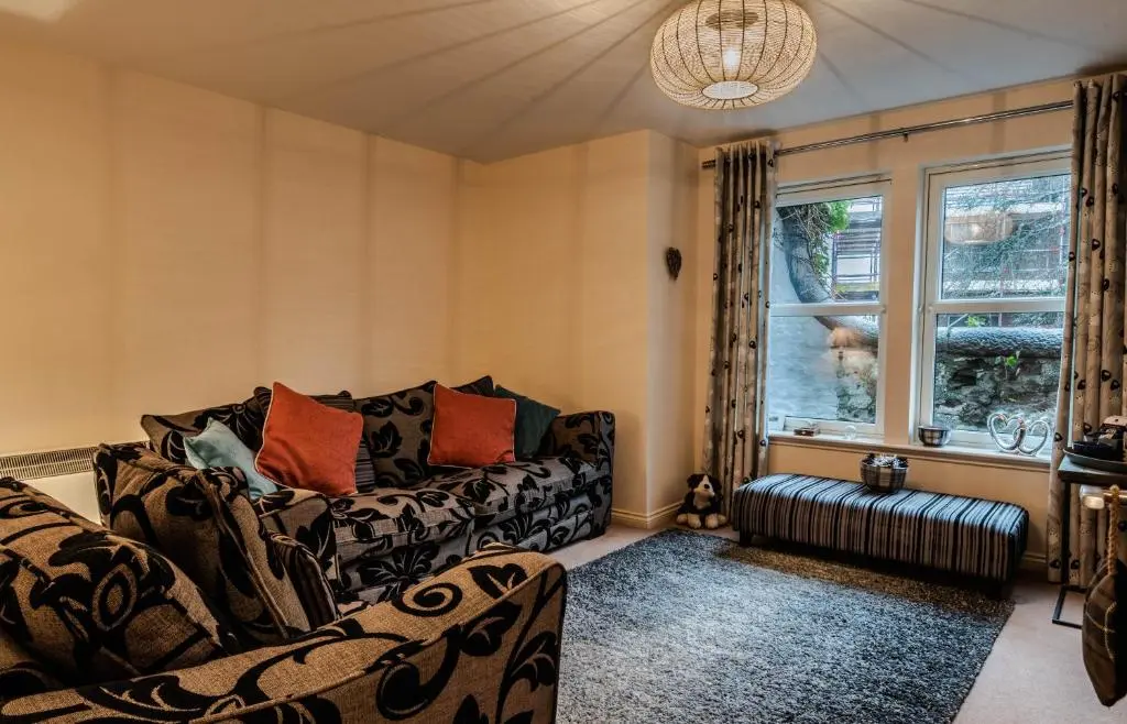 a living room with a couch and a window at No.3 On The Square in Beauly