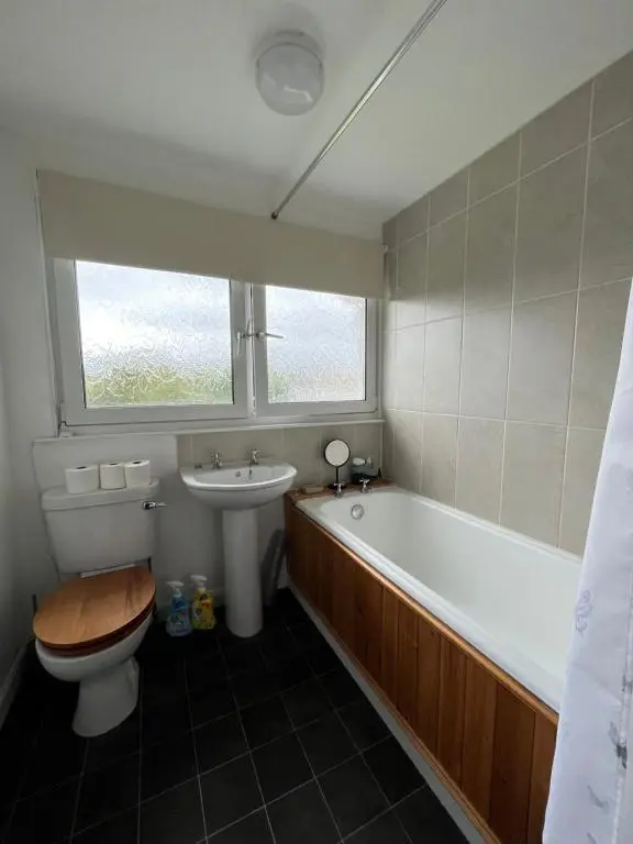 a bathroom with a tub and a toilet and a sink at Inverness House in Inverness
