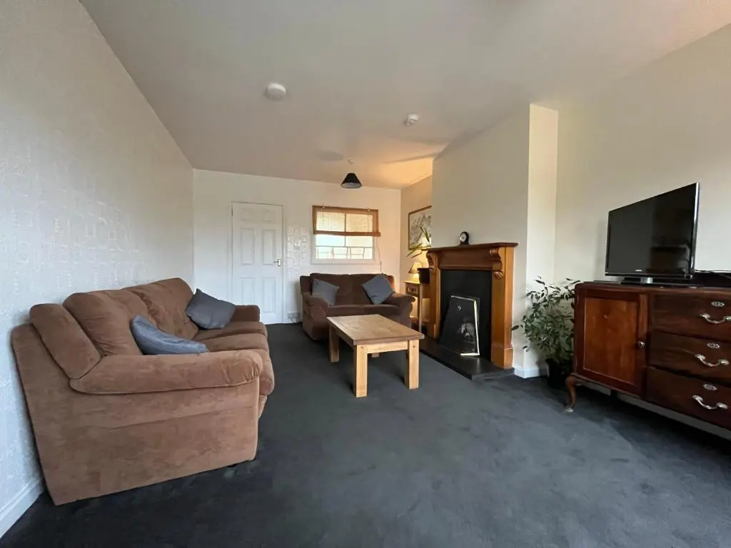 a living room with a couch and a tv at Inverness House in Inverness