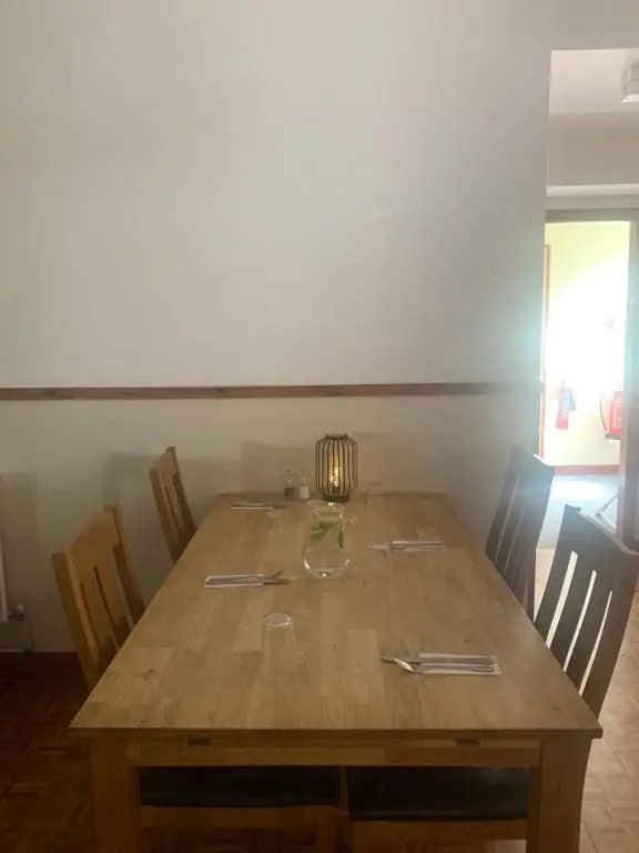 a wooden table with chairs and a lamp on it at Fairburn Activity Centre in Contin