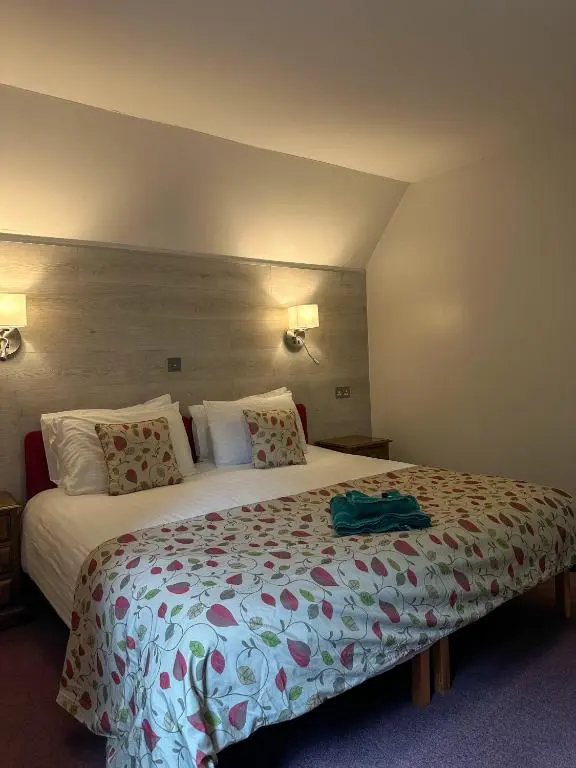 a hotel room with a large bed in a room at Fairburn Activity Centre in Contin
