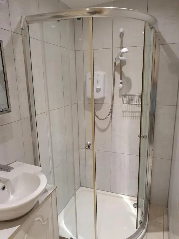 a bathroom with a shower and a toilet and a sink at Nanny's little highland hoose in Inverness