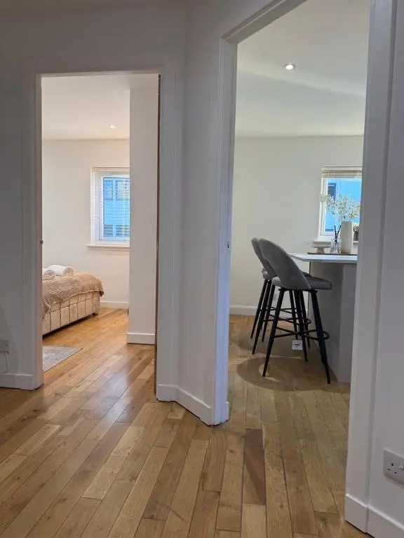 a room with a bedroom and a table and a chair at Gateway Apartment in Inverness