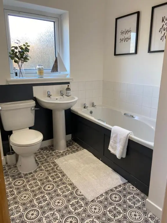 a bathroom with a tub and a toilet and a sink at Gateway Apartment in Inverness