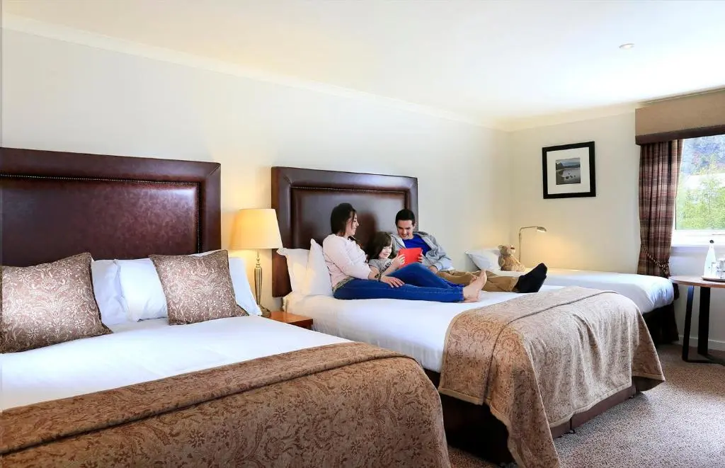 two women sitting on beds in a hotel room at Macdonald Aviemore Hotel at Macdonald Aviemore Resort in Aviemore