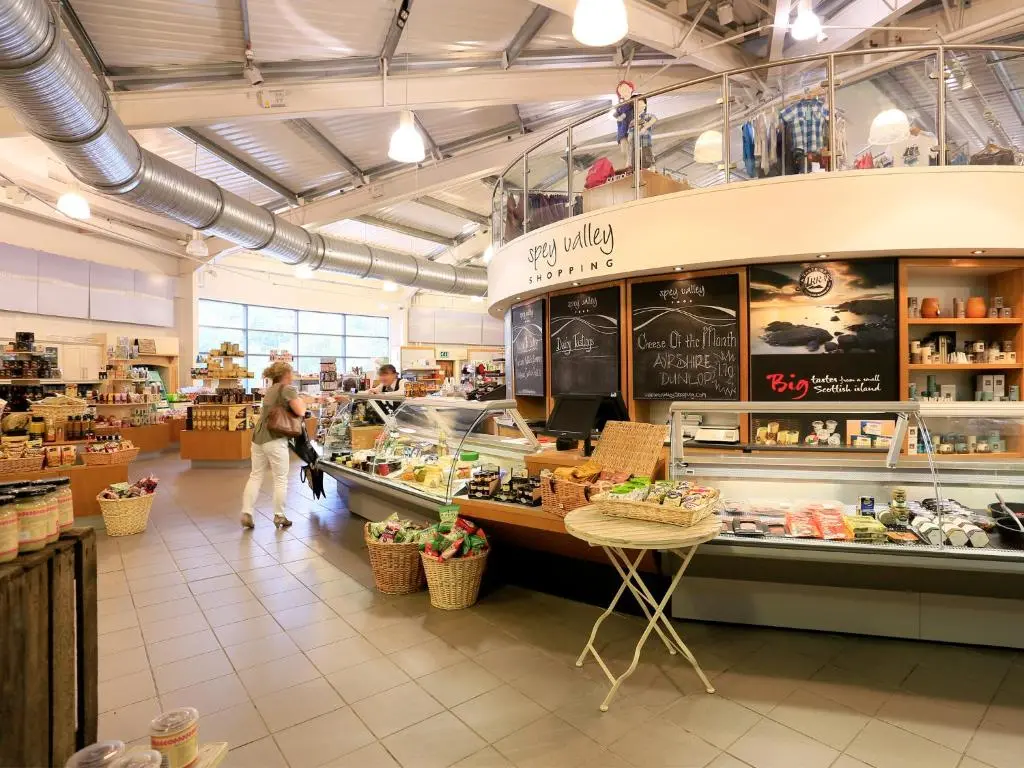 a grocery store with people walking in the aisle at Macdonald Aviemore Hotel at Macdonald Aviemore Resort in Aviemore