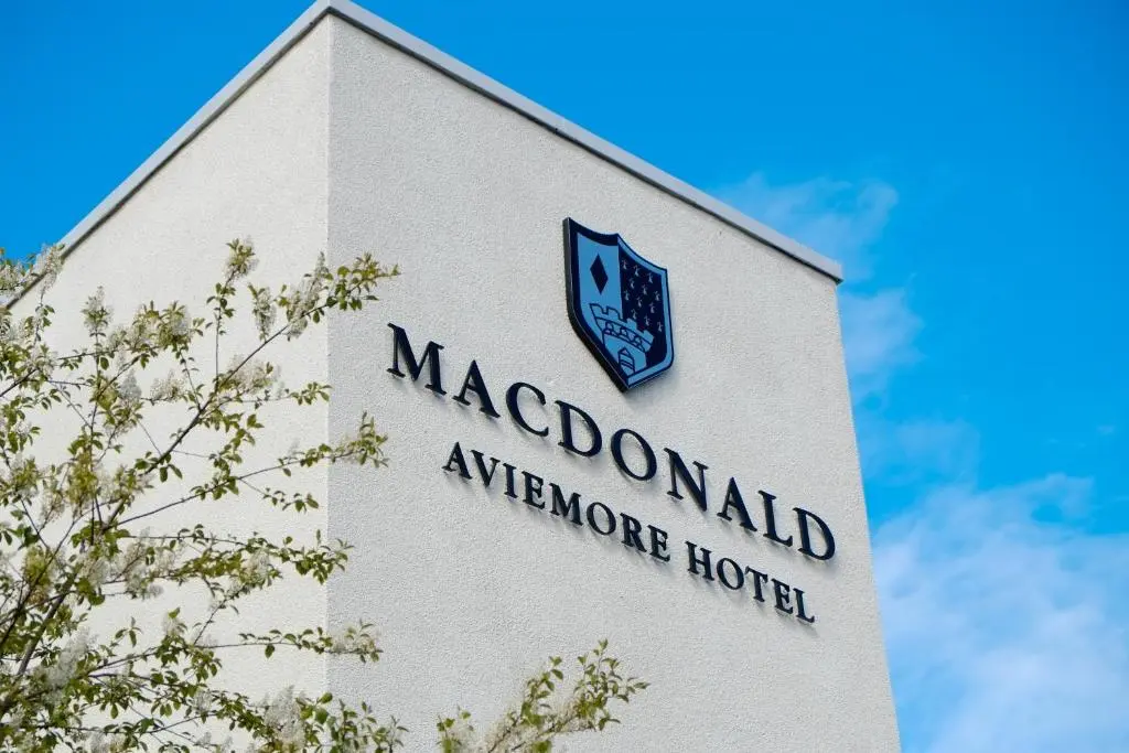 a sign for a macdonald appliance hotel on a building at Macdonald Aviemore Hotel at Macdonald Aviemore Resort in Aviemore