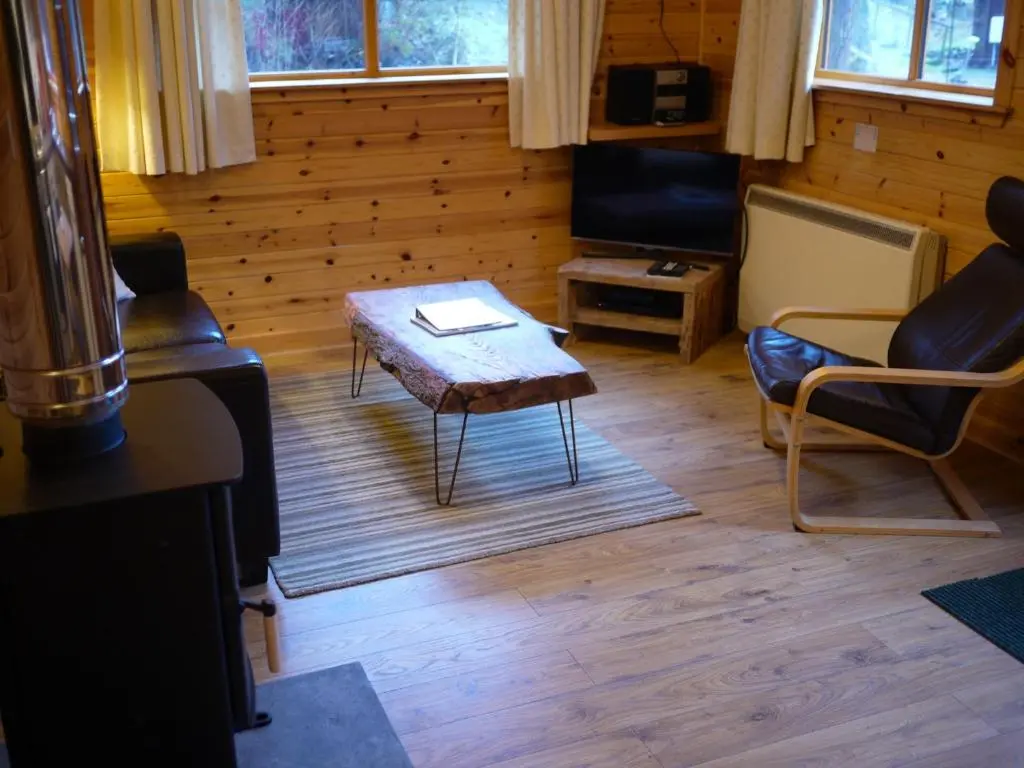 a living room with a coffee table and chairs at Dulnain in Aviemore
