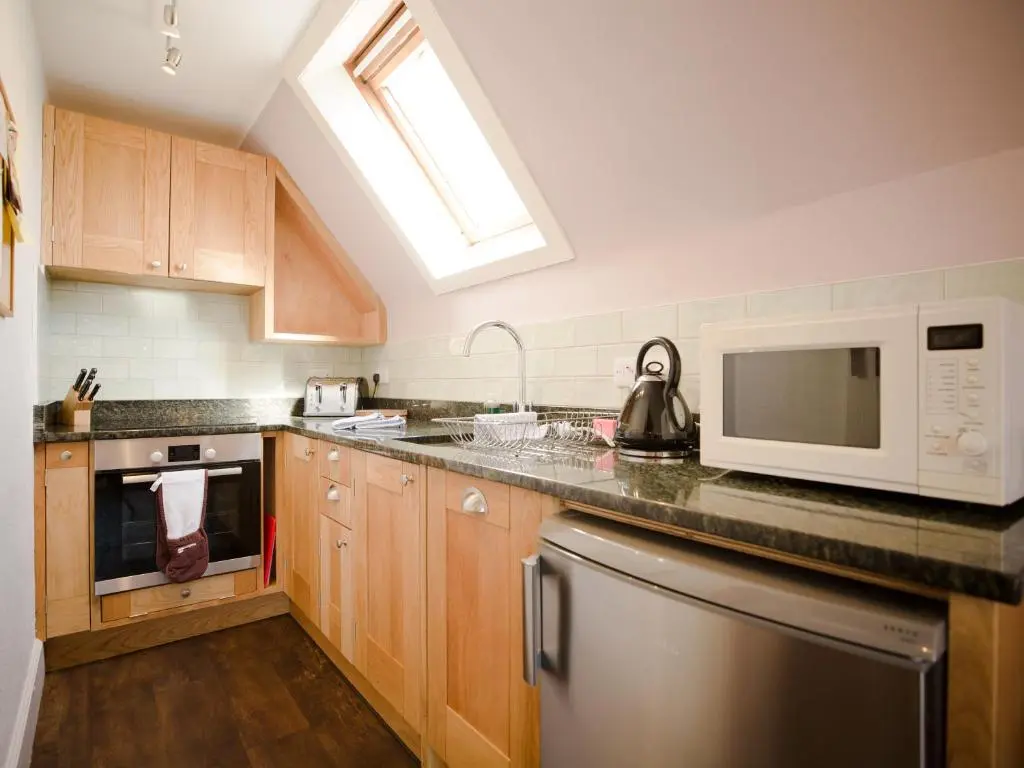 a kitchen with a sink and a microwave at Ptarmigan in Aviemore