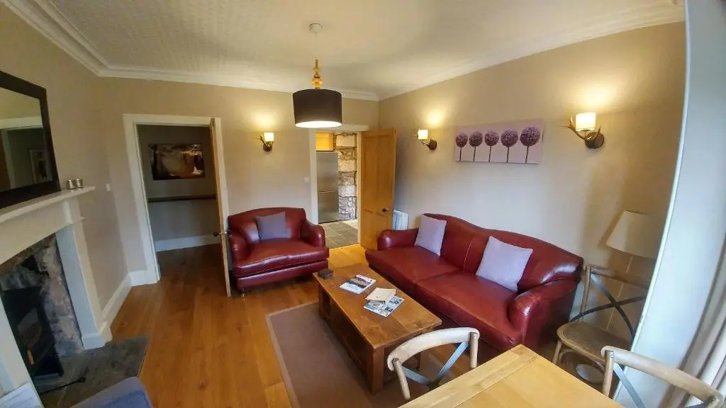 a living room with a couch and a table at Shieling in Aviemore
