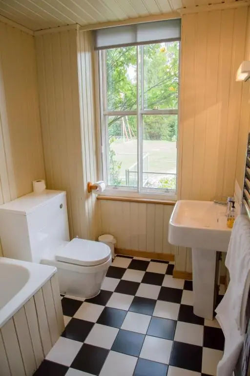 a bathroom with a toilet and a sink and a window at Shieling in Aviemore