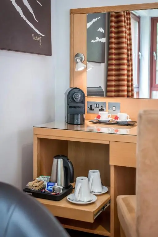 a table with a coffee maker and cups on it at High Range Lodge Hotel in Aviemore