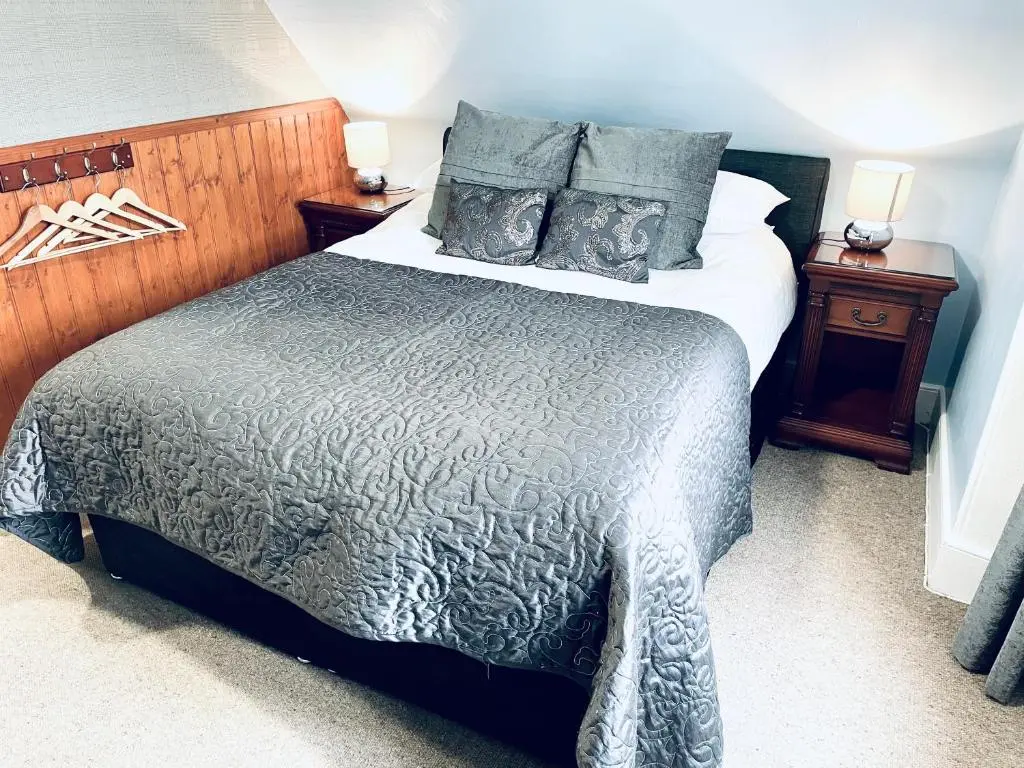 a bedroom with a large bed and two night stands at Invergarry Hotel in Invergarry