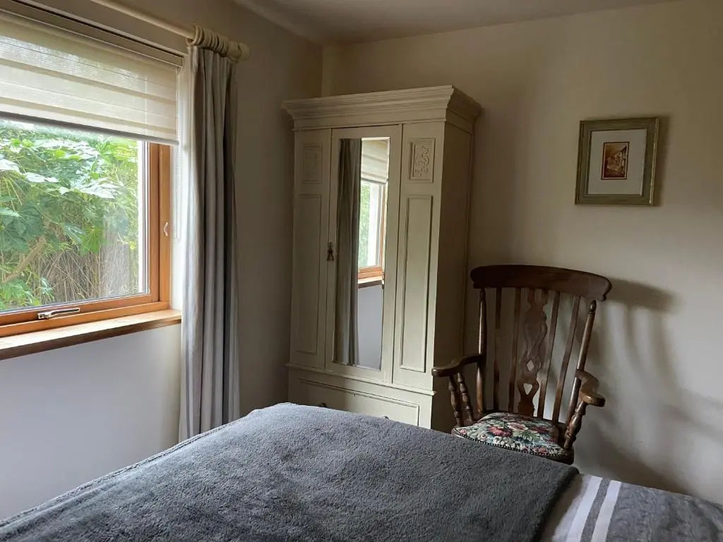 a bedroom with a bed and a window and a chair at Old Mills Garden in Elgin