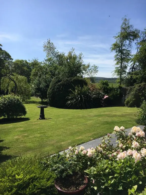 a garden with pink flowers in a yard at Old Mills Garden in Elgin