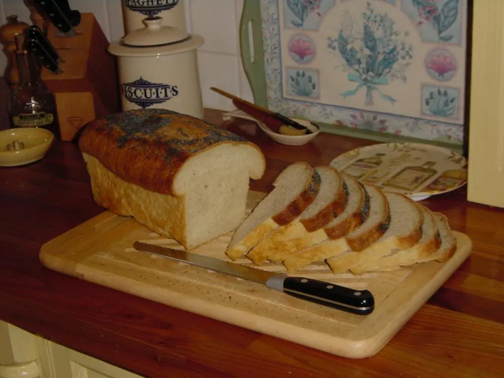 a cutting board with a loaf of bread and a knife at Willowbank in Grantown on Spey