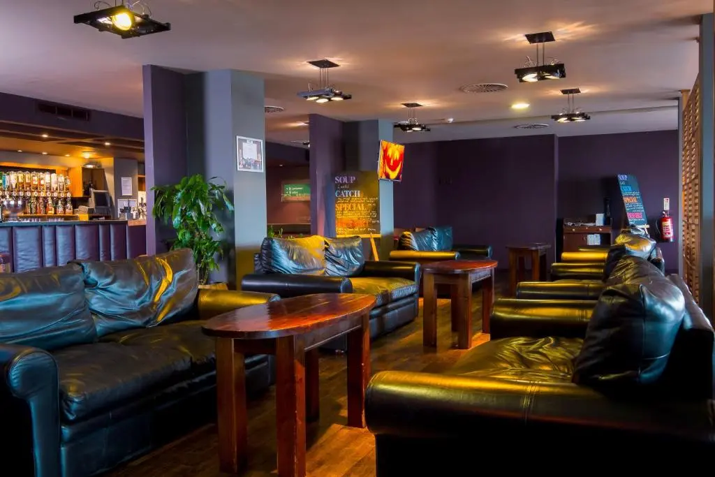 a bar with leather couches and tables in a room at Holiday Inn Aberdeen West by IHG in Westhill