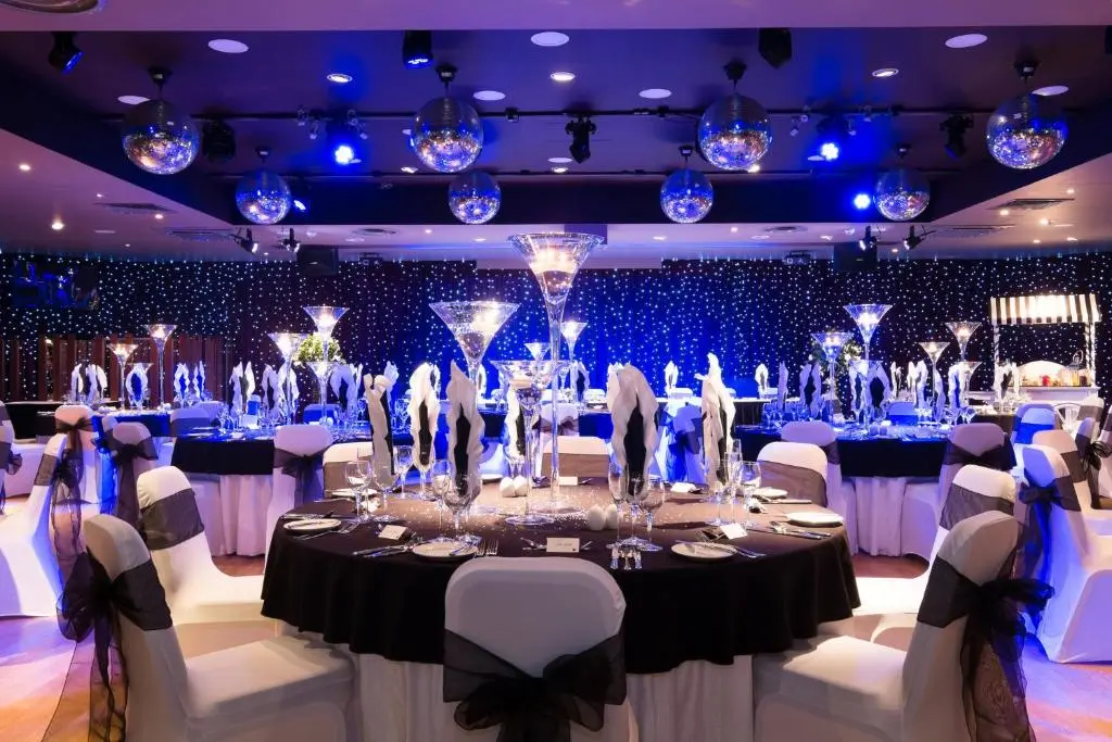 a ballroom with a table with white chairs and blue lights at Holiday Inn Aberdeen West by IHG in Westhill