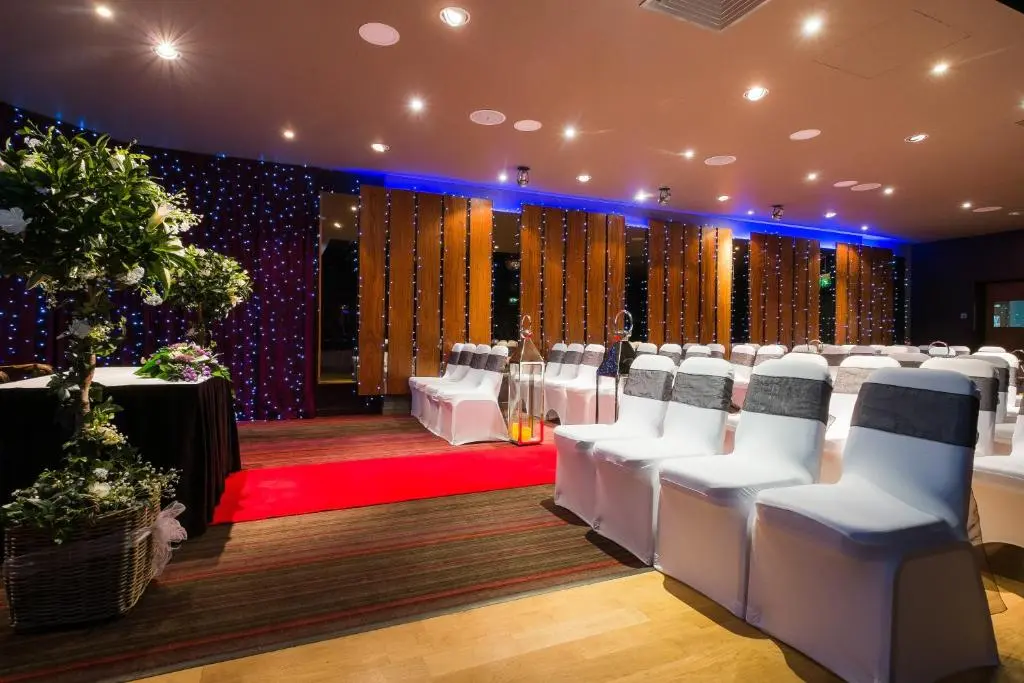 a conference room with white chairs and a red carpet at Holiday Inn Aberdeen West by IHG in Westhill