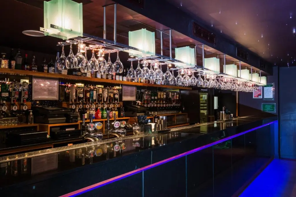 a bar with a lot of glasses on the wall at Holiday Inn Aberdeen West by IHG in Westhill