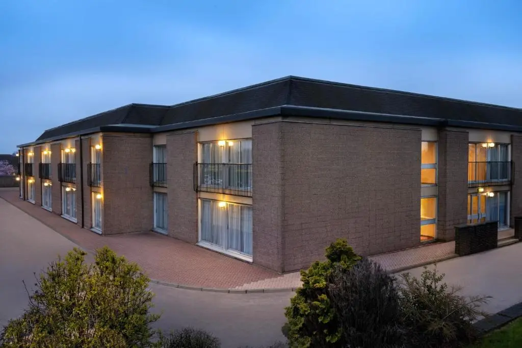 a large brick building with a lot of windows at The Aberdeen Dyce Hotel in Dyce