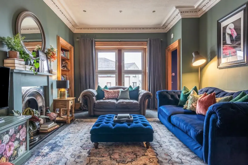 a living room with blue couches and a fireplace at The Nessting Place in Inverness